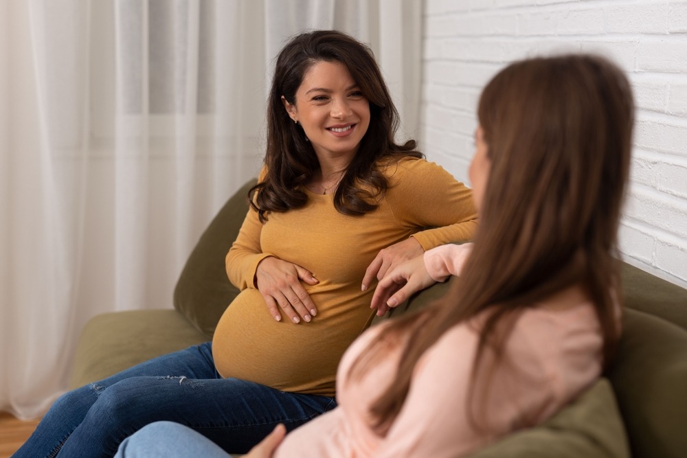 Two Pregnant Friends Sitting And Having Nice Time Together