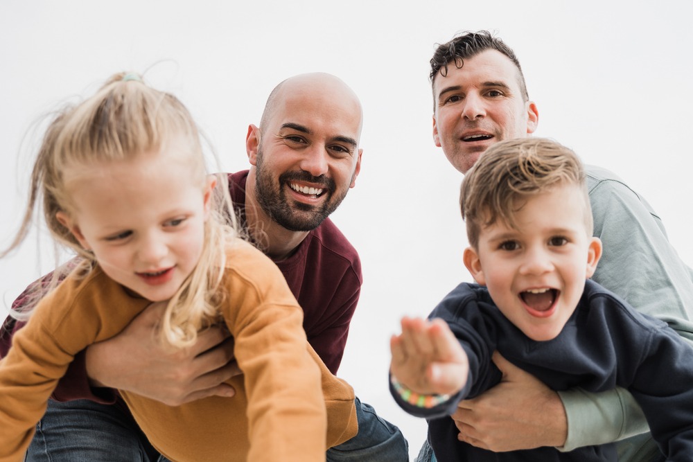 A gay couple with holding two children