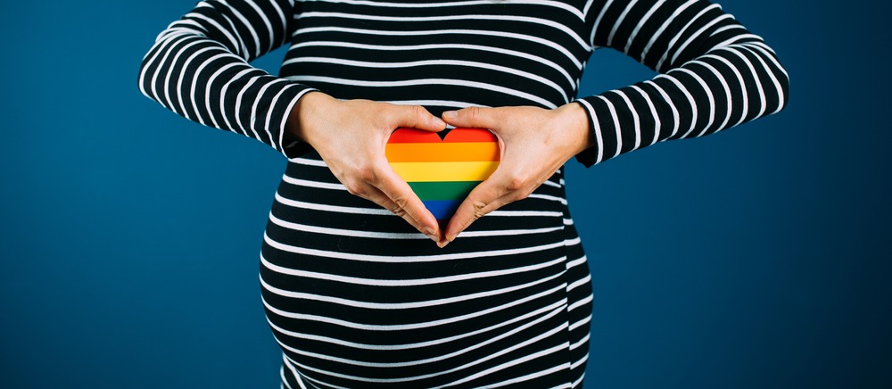 Closeup Of Pregnant Woman Holding A Rainbow Colored Hearth.